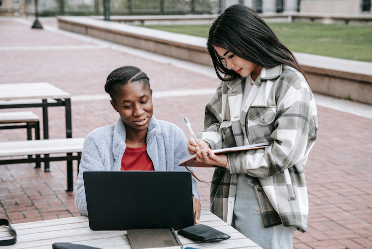 students working on a laptop outdoors